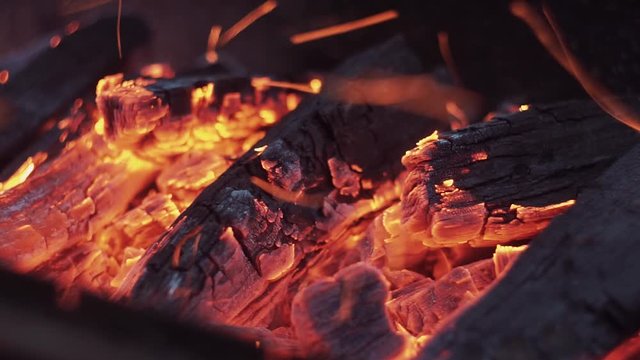 Embers and ashes of mighty big fireplace ablaze, sparks and ash in the fire place in the wind. Burning in a fire. Texture. Background. Burn fire and bright coals.
