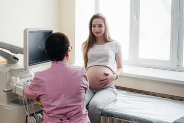 A pregnant girl is advised by a doctor after an ultrasound in the clinic. Medical examination