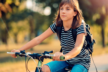 Fototapeta na wymiar Girl riding a bike to school