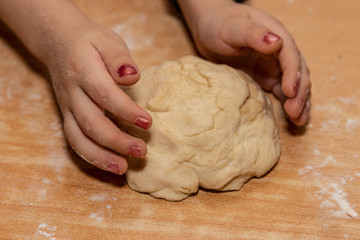 hand of child grandmother teaches granddaughter to bake pies with cabbage