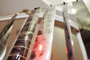 Medium format and 35mm photo film negative hanging drying on a rope line in bathroom analogue photography