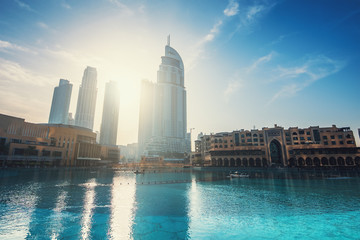 Fototapeta na wymiar Downtown Dubai district with high rise buildings in sunrise sunlight and pool. United Arab Emirates, UAE.