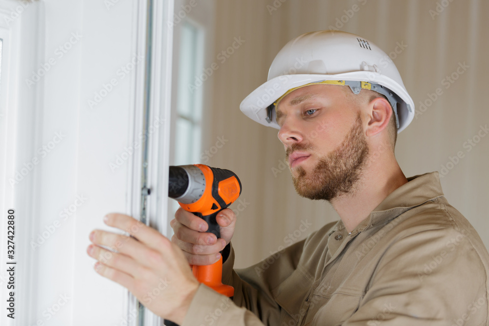 Wall mural carpenter at door lock installation or repair