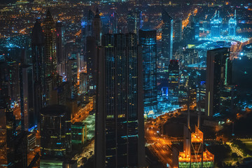 Modern skyscrapers, illuminated roads at night in luxury downtown of Dubai city skyline, UAE. View from above.