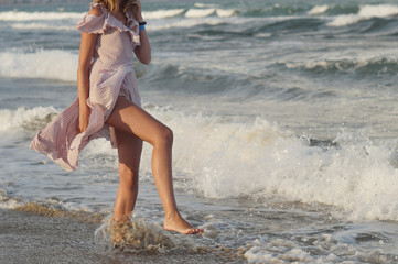 Girl on the seashore in a summer dress, vacation by the sea.