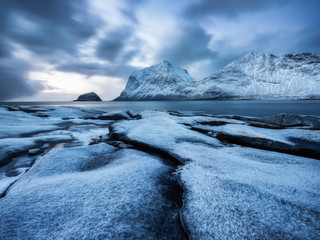 Haukland beach, Lofoten islands, Norway. Landscape with long exposure shot. Mountains, beach and clouds. Winter landscape near the ocean. Norway - travel