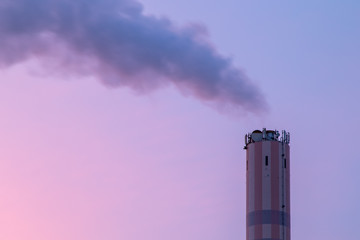 chimney of an incineration plant, dawn windy morning