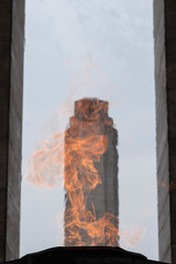 Tower of the National Flag Memorial seen through the fire of the votive flame