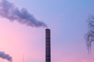 chimney of an incineration plant, dawn windy morning