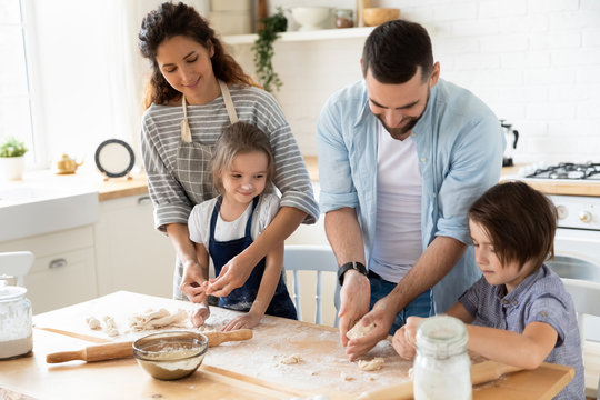 Happy family with kids baking in kitchen together - Powered by Adobe