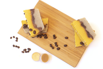 Natural cosmetic on the wooden board. The shadow of the fern. Coffee beans. Hand made soap and lip balm. White background