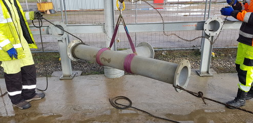 riggers move the pipe using two chain blocks