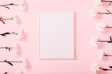 Beautiful flowers composition. White photo frame, white flowers on pastel pink background. Valentines Day, Happy Women's Day, Mother's day. Flat lay, top view, copy space