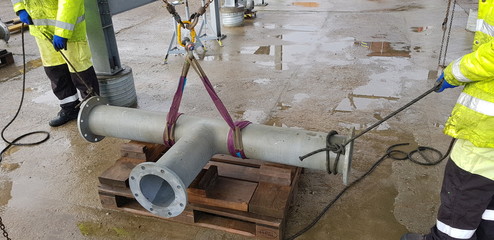 riggers move the pipe using two chain blocks