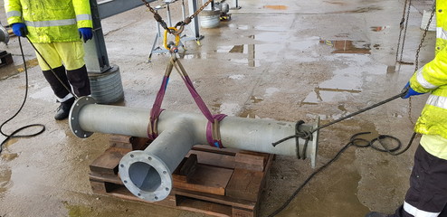 riggers move the pipe using two chain blocks