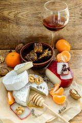 Rustic cheese platter with camembert, brie, gouda on wooden table,
