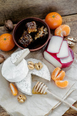 Rustic cheese platter with camembert, brie, gouda on wooden table,