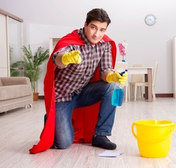 Super hero husband cleaning floor at home