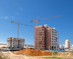 City construction in desert dunes. Building yard of Housing construction of houses in a new area of...