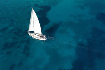 Aerial drone photo of beautiful sail boat cruising in tropical exotic island bay resembling a blue...