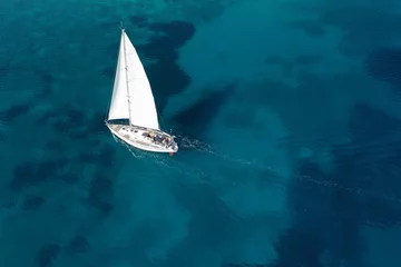 Fotobehang Aerial drone photo of beautiful sail boat cruising in tropical exotic island bay resembling a blue lagoon © aerial-drone