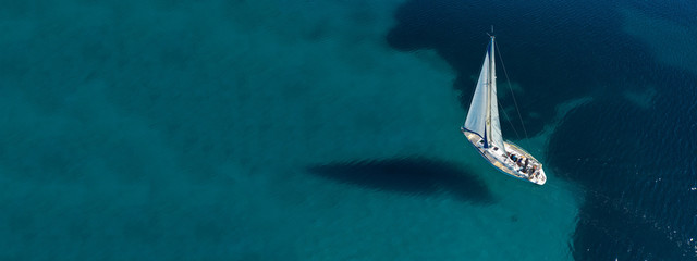 Aerial drone ultra wide photo of beautiful sail boat sailing in tropical exotic bay with emerald...