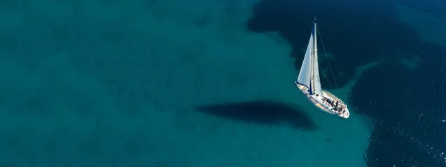 Fotobehang Aerial drone ultra wide photo of beautiful sail boat sailing in tropical exotic bay with emerald clear sea © aerial-drone