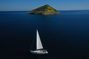 Aerial drone photo of beautiful sail boat near Raftis island as seen at spring, Attica, Greece