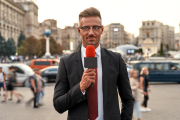 Always Ahead. Professional reporter presenting the news on urban street. Journalism industry, live...