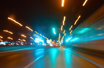 City colorful night lights perspective blurred by high speed of the car. A streak of light, trails.