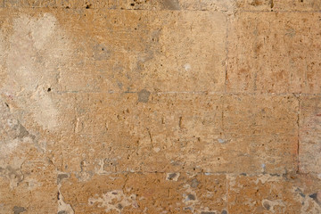 wall of yellow rectangular stones with cement, fragment of ancient architecture