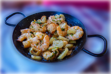 Delicious snack fried shrimp with garlic in a black pan