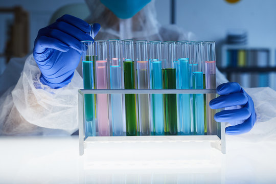Background image of scientist holding test tubes with colored liquid in medical laboratory, copy space