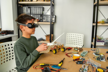 Imagine it. Child programming, testing robot vehicle, using console controller, working with wires and circuits at stem class.