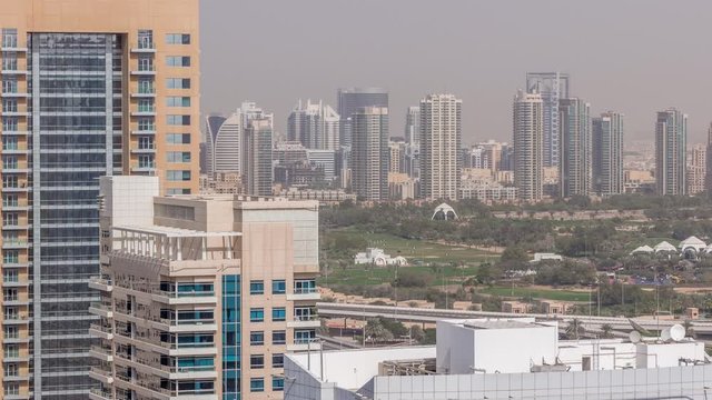 Dubai Golf Course with a cityscape of Gereens and tecom districts at the background aerial timelapse. Top view from Dubai marina