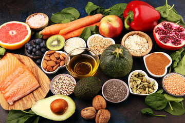 Healthy food clean eating selection: fish, fruit, vegetable, cereal, leaf vegetable on rustic background