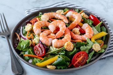 Fresh shrimp and greens salad on light background