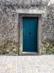 Fototapeta na wymiar old blue wooden door in stone wall