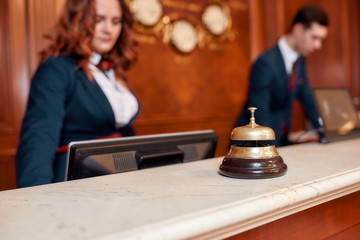We always hear you. Attractive executives at the reception desk of a hotel in the background. Focus...