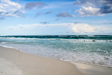 Deep colored ocean waves rolling onto shore