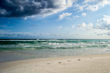 Deep colored ocean waves rolling onto shore