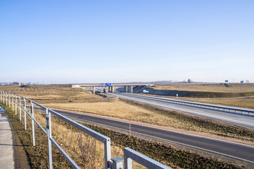 Fototapeta na wymiar Empty asphalt highway in spring with bridge