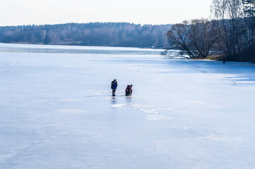 Fishermen fish on ice on the river. Winter fishing