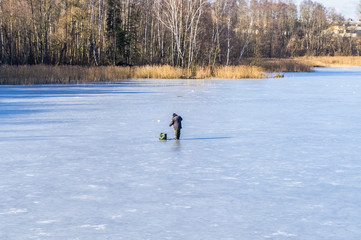 Fototapeta na wymiar Fishermen fish on ice on the river. Winter fishing