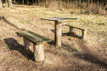 Old wooden bench with a table in the park