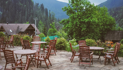 Armchairs with round table at balcony to outdoor background of green natural forest and mountain