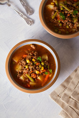 Bowl of ground beef soup with vegetables. Healthy food. Flat lay vertical image