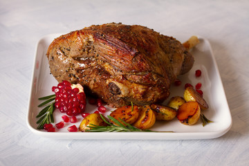 Roast leg of lamb with potatoes, pomegranate and rosemary