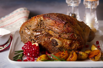 Roast leg of lamb with potatoes, pomegranate and rosemary