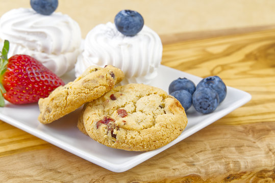 Oat cookies with Strawberry and bize cookies with blueberry on olive wood board